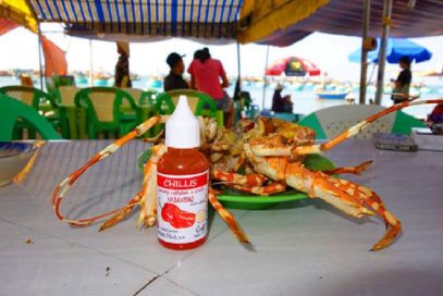 Krab a fľaštička Chillis na stole pri mori vo Vietname