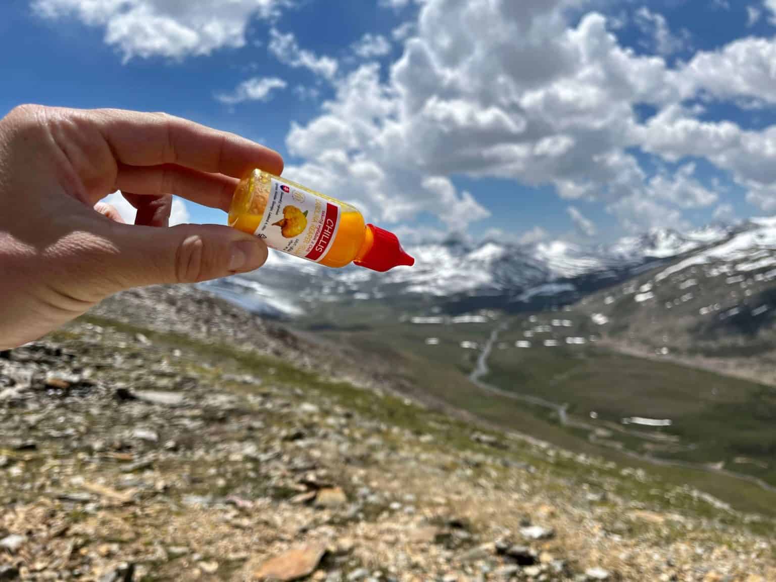 Fľaštička Chillis v ruke na pozadí hôr v Pakistane