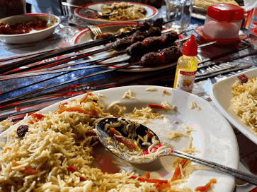Grilované mäso, ryža a fľaštička Chillis na stole